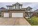 Exterior of a two-story home with a three-car garage, lush landscaping, and well-manicured lawn at 5426 S Jasper Way, Centennial, CO 80015