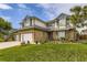 Charming two-story home with a three-car garage, lush lawn, and colorful flower beds at 5426 S Jasper Way, Centennial, CO 80015