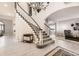Inviting foyer featuring a grand staircase with elegant chandelier and wood-look flooring at 5426 S Jasper Way, Centennial, CO 80015