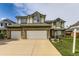 Two story brick home with three car garage, well manicured lawn and colorful flower beds at 5426 S Jasper Way, Centennial, CO 80015