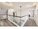 Spacious hallway with plush carpet, white railings, and elegant chandelier lighting fixtures at 5426 S Jasper Way, Centennial, CO 80015