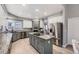 Contemporary kitchen with grey cabinets, granite countertops, stainless appliances, and central island cooktop at 5426 S Jasper Way, Centennial, CO 80015