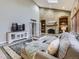 Comfortable living room includes a brick fireplace, built-in shelving, and plentiful natural light at 5426 S Jasper Way, Centennial, CO 80015