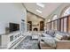 Bright living room with brick fireplace, skylights, and large sectional sofa at 5426 S Jasper Way, Centennial, CO 80015