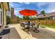 Spacious patio with outdoor dining set, red umbrella, and views of the fenced backyard at 5426 S Jasper Way, Centennial, CO 80015