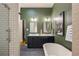 Stylish bathroom featuring a glass shower and a dual sink vanity with green walls at 2355 N Emerson St, Denver, CO 80205