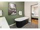 Elegant bathroom with a freestanding tub, stylish fixtures, and artistic wall decor at 2355 N Emerson St, Denver, CO 80205