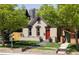 Charming home featuring a well-kept front yard, red door, and beautiful architecture against a downtown skyline at 2355 N Emerson St, Denver, CO 80205