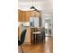 Open kitchen with stainless appliances, quartz counters, island with bar seating, and hardwood floors at 2355 N Emerson St, Denver, CO 80205