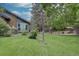 Lush backyard features a well-manicured lawn, mature trees, patio, and charming details creating a tranquil outdoor space at 7715 S Hudson Ct, Centennial, CO 80122