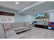 Finished basement features gray sofa and a mounted television at 7715 S Hudson Ct, Centennial, CO 80122