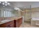 Spacious bathroom featuring a double vanity, granite countertop, and large glass shower with tub at 7715 S Hudson Ct, Centennial, CO 80122