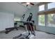 Home gym area with elliptical, weight bench, and natural light from large windows at 7715 S Hudson Ct, Centennial, CO 80122