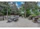Spacious brick patio furnished with a dining table, rocking chairs, and lush landscaping, ideal for outdoor entertaining at 7715 S Hudson Ct, Centennial, CO 80122