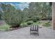 Inviting outdoor brick patio with a comfortable chair, overlooking the beautiful backyard with mature trees at 7715 S Hudson Ct, Centennial, CO 80122