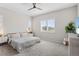 A bright bedroom featuring a ceiling fan, carpeted floors, and a window with white shutters at 21894 E Tufts Cir, Aurora, CO 80015