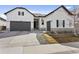 Charming two-story home featuring a well-manicured lawn, gray garage doors, and an inviting entrance at 21894 E Tufts Cir, Aurora, CO 80015