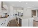 Open kitchen with a large island, stainless steel appliances, white cabinetry, and a subway tile backsplash at 21894 E Tufts Cir, Aurora, CO 80015