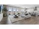 Open-concept living room with natural light, hardwood floors, and a large sectional sofa at 21894 E Tufts Cir, Aurora, CO 80015