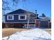 Two-story home with a red door, blue siding and a brick facade, with snow on the ground at 1731 S Naples St, Aurora, CO 80017