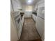 Galley kitchen featuring white cabinets, appliances, and tile floors at 1533 S Jamaica St, Aurora, CO 80012