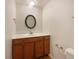 Updated bathroom with brown vanity and oval mirror at 1772 Robb St, Lakewood, CO 80215