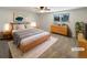 Virtually staged main bedroom with light wood furniture and new carpet at 1772 Robb St, Lakewood, CO 80215