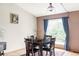 Bright dining room featuring a window, hardwood floors, table with chairs, and blue curtains at 11502 W 101St Avenue, Westminster, CO 80021