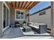 Cozy covered patio area with comfortable wicker seating and a stylish outdoor heater at 3953 John Ave, Castle Rock, CO 80104