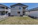 Spacious backyard with a well-maintained lawn, patio seating, grill, and a charming white fence at 3953 John Ave, Castle Rock, CO 80104