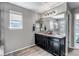 Bathroom featuring dual vanities, large mirror, decorative lighting, and stylish wood look floors at 3953 John Ave, Castle Rock, CO 80104