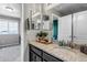 Bathroom with granite vanity, decorative mirrors, and an open doorway at 3953 John Ave, Castle Rock, CO 80104