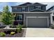 Two story home with two car garage, a tree, and a small front yard at 3953 John Ave, Castle Rock, CO 80104