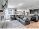Open concept living room features sleek gray leather furniture and leads into the kitchen at 3953 John Ave, Castle Rock, CO 80104