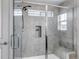 Elegant glass-enclosed shower with gray tiled walls, a bench, and dual shower heads at 3953 John Ave, Castle Rock, CO 80104