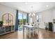 Bright dining room with hardwood floors, modern chandelier, and sliding glass doors to the backyard at 652 Pinecliff Dr, Erie, CO 80516