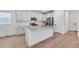 Updated kitchen with stone countertops, stainless appliances, white cabinetry, and wood-look flooring at 3336 N Haleyville Ct, Aurora, CO 80019