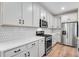 Updated kitchen boasting white cabinets, granite counters, stainless appliances, and wood-look flooring at 3336 N Haleyville Ct, Aurora, CO 80019