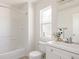 Bright bathroom features a shower-tub combo, vanity and window at 4555 Andes St, Denver, CO 80249