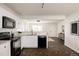 Bright kitchen with modern appliances, white cabinetry, and an open design to the living area at 4555 Andes St, Denver, CO 80249