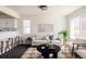 Inviting living room features neutral tones, plush seating, and a seamless flow into the kitchen area at 4555 Andes St, Denver, CO 80249