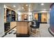 Basement wet bar featuring a black countertop, island and cabinetry adding elegance to the entertainment space at 1193 Phipps Ct, Highlands Ranch, CO 80126