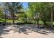 Backyard basketball court with adjustable hoop is surrounded by mature trees and professionally landscaped yard at 1193 Phipps Ct, Highlands Ranch, CO 80126