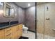 A luxurious bathroom has a granite countertop, unique mirror, and stand-up shower with custom tile at 1193 Phipps Ct, Highlands Ranch, CO 80126