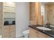 Compact bathroom featuring modern fixtures, glass shelving and stylish granite countertop and cabinet at 1193 Phipps Ct, Highlands Ranch, CO 80126