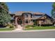 Stately brick home featuring a tile roof, manicured landscaping, and a welcoming entrance at 1193 Phipps Ct, Highlands Ranch, CO 80126