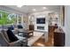 Comfortable living room with a fireplace, custom built-ins, and a large window at 1193 Phipps Ct, Highlands Ranch, CO 80126