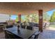 An outdoor kitchen is situated on a covered patio with a grill and dining space at 1193 Phipps Ct, Highlands Ranch, CO 80126