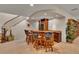 Basement wet bar with granite countertop, seating for four, and stairs to upper level at 11 Canon Pl, Greenwood Village, CO 80111