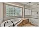 Bright bathroom featuring a glass block window over a soaking tub and a glass-enclosed shower at 11 Canon Pl, Greenwood Village, CO 80111